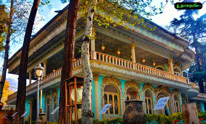 نمای بیرونی عمارت موزه زمان با معماری قاجاری، درختان بلند و نورپردازی گرم